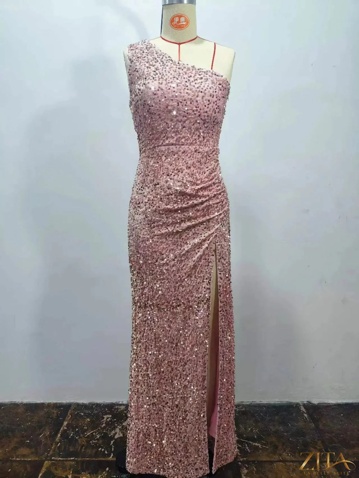 Zita La Belle Elite one-shoulder ruched sequin high-slit evening dress displayed on a model, featuring a glamorous design.