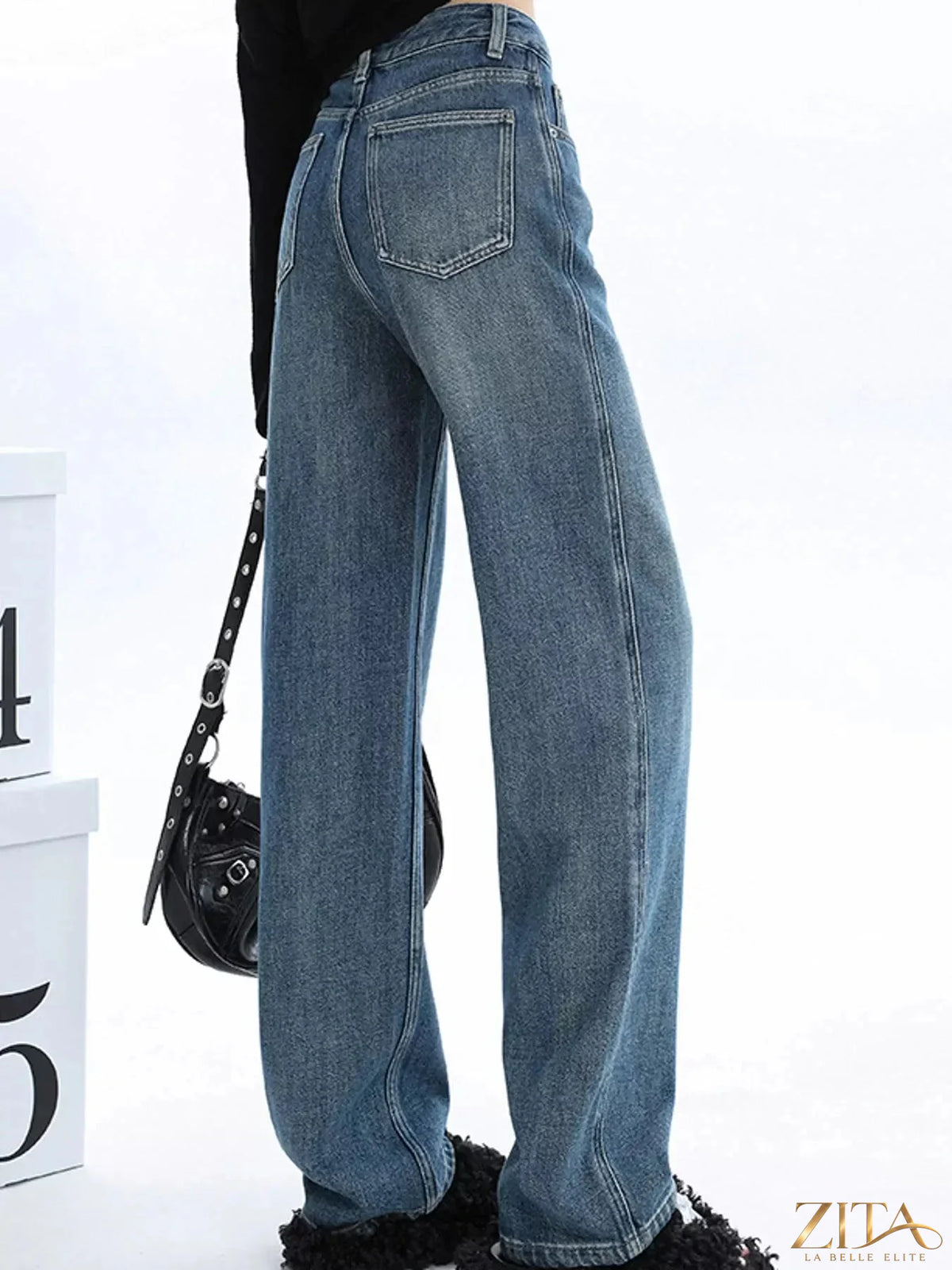 High-waisted vintage wash wide-leg jeans by Zita La Belle Elite, displayed on a model with a casual pose.