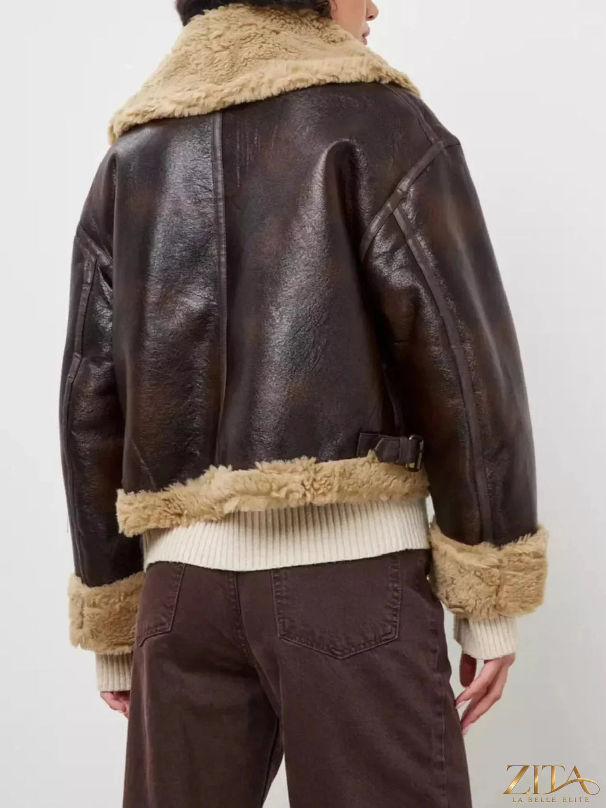Vintage-inspired faux leather aviator jacket with plush shearling trim, featuring classic zip details and adjustable straps by Zita La Belle Elite
