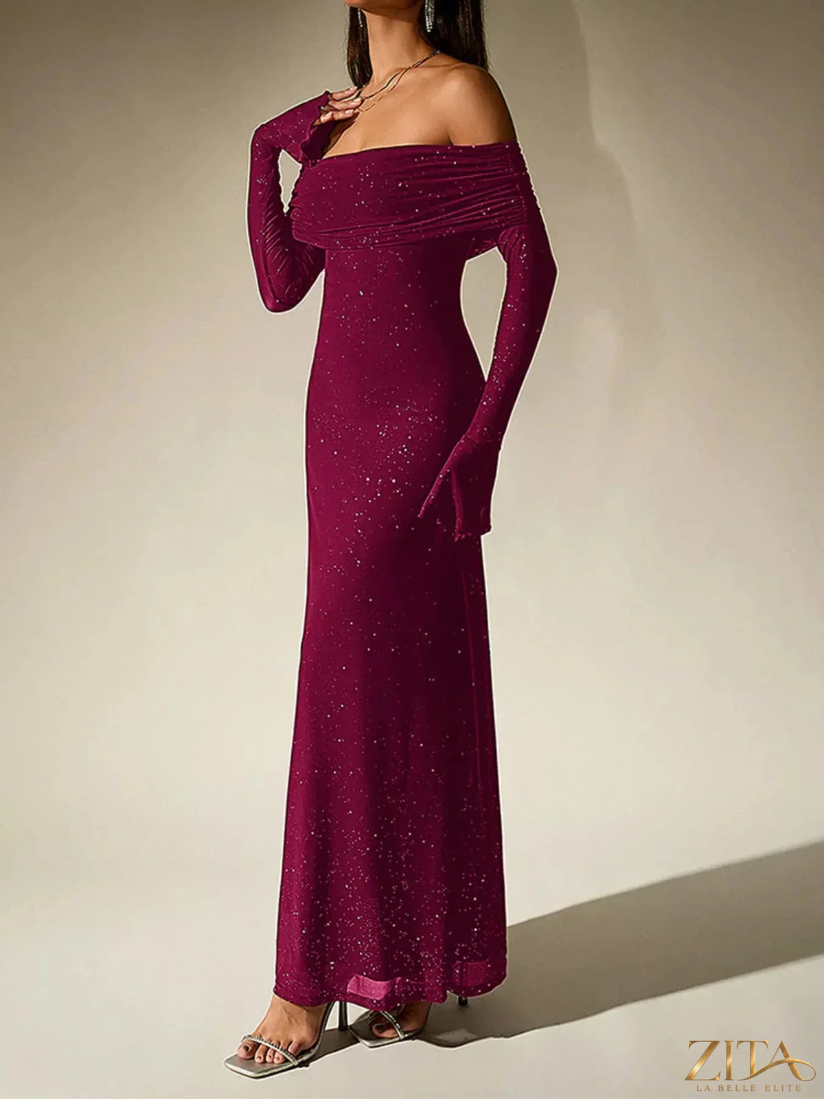Glitter off-shoulder maxi dress by Zita La Belle Elite with flowing fabric and shimmering embellishments, styled for elegant occasions.