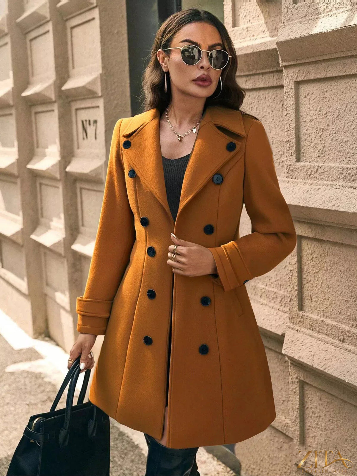 Zita La Belle Elite double-breasted wool blend overcoat hanging on a wooden rack, showcasing classic style and tailored fit.