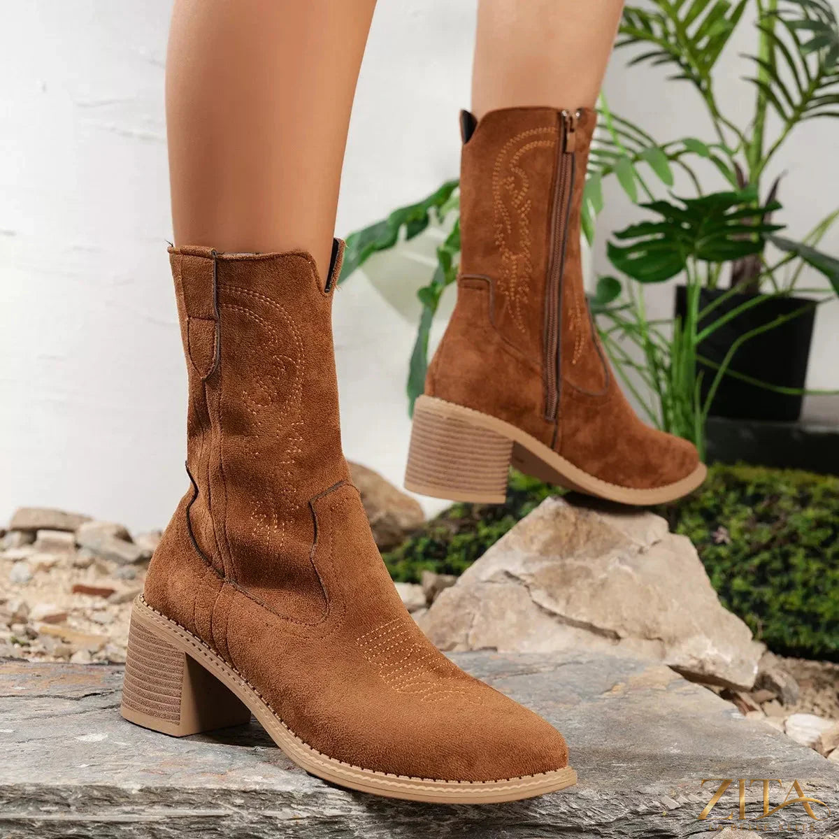 Trendsi suede block heel western boots featuring pointed toes and classic western stitching on a rich brown leather background.