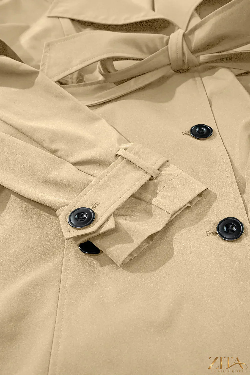 Zita La Belle Elite trench coat with collared neck, long sleeves, waist buttons, and a tie waist for a stylish look.