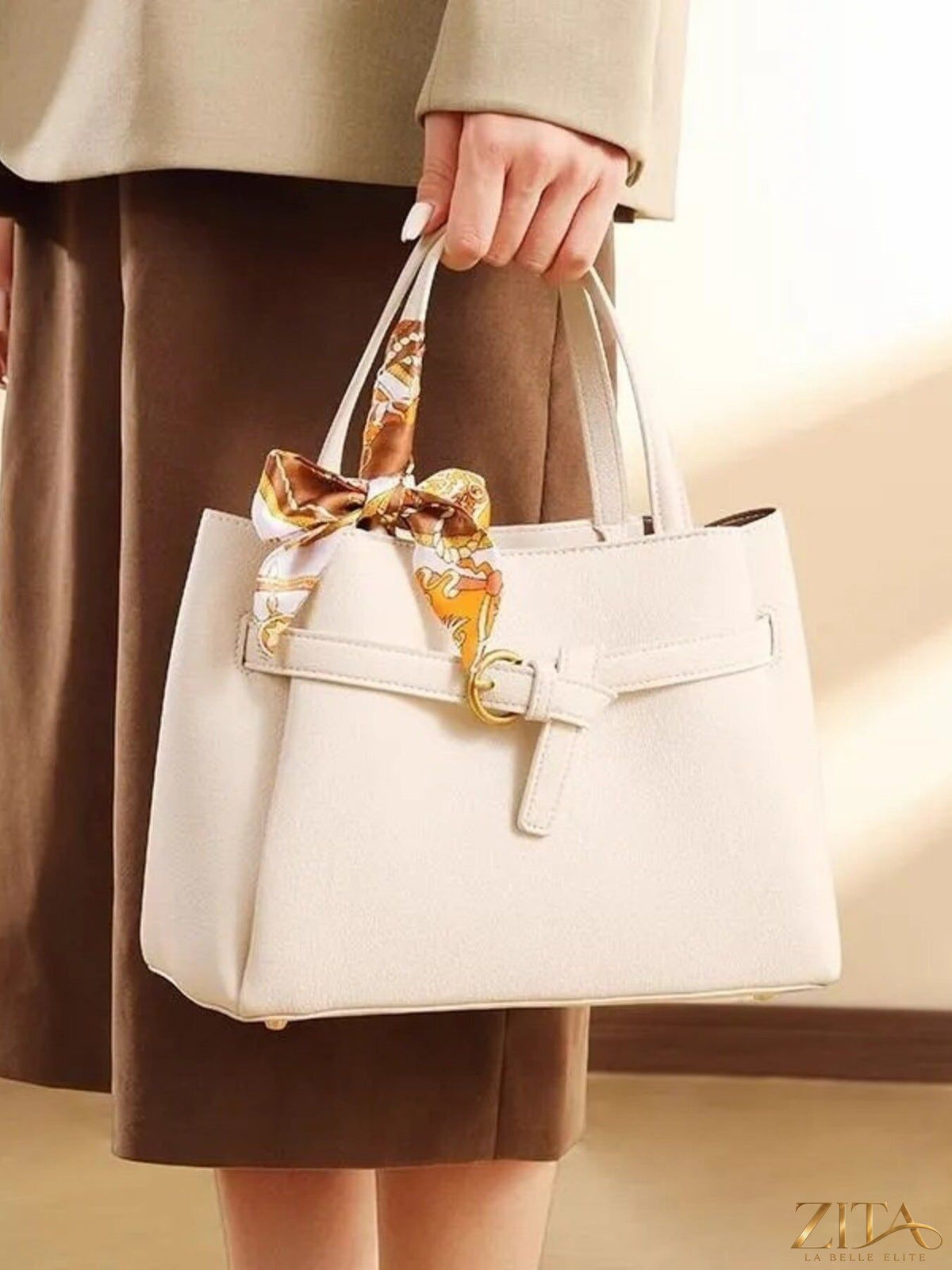 Zita La Belle Elite leather top handle handbag with sturdy handles and sleek design on a neutral background.