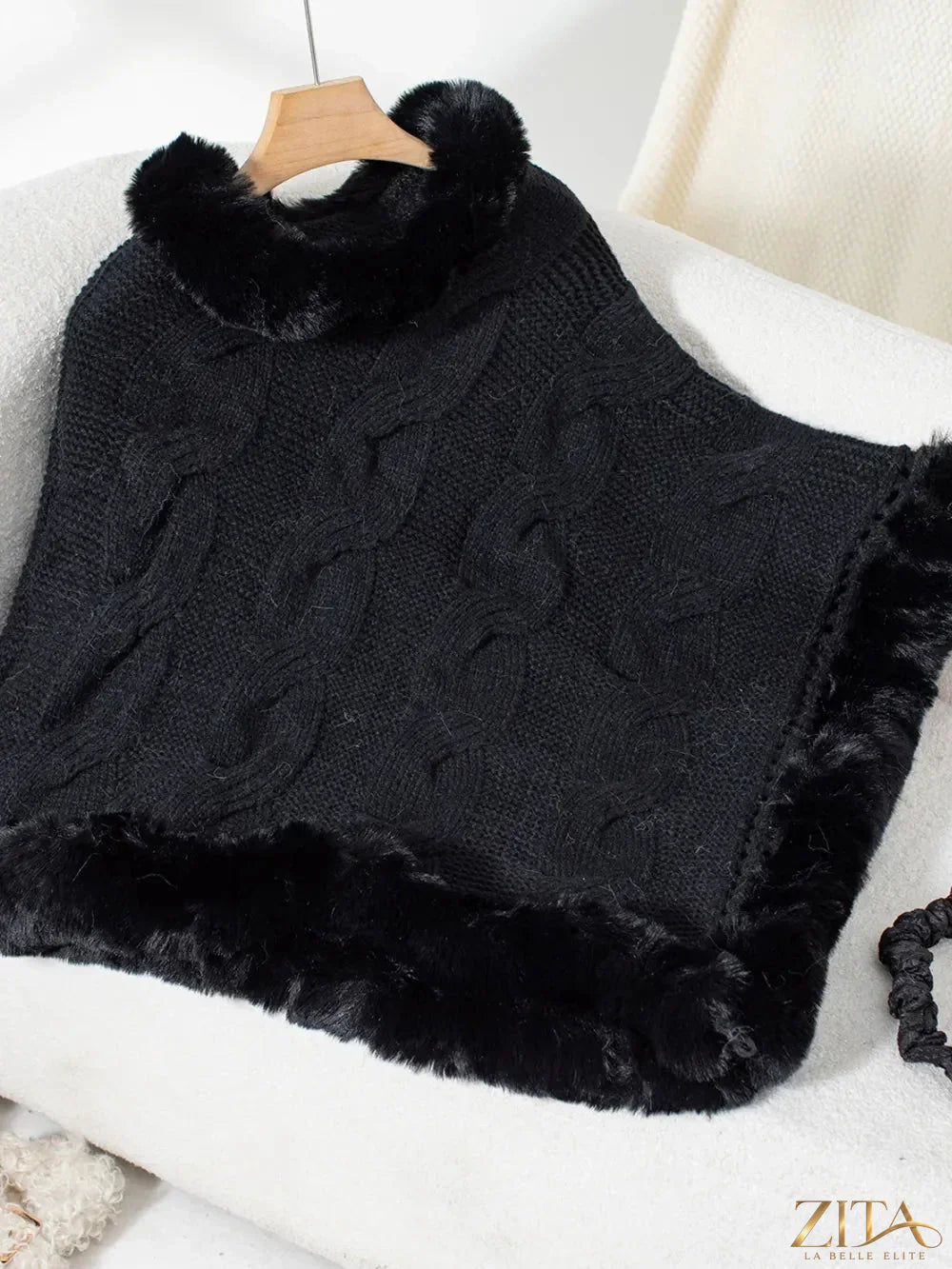 Fuzzy hem cable-knit poncho from Trendsi featuring cozy, textured knit with a relaxed fit and fringed hem detail.