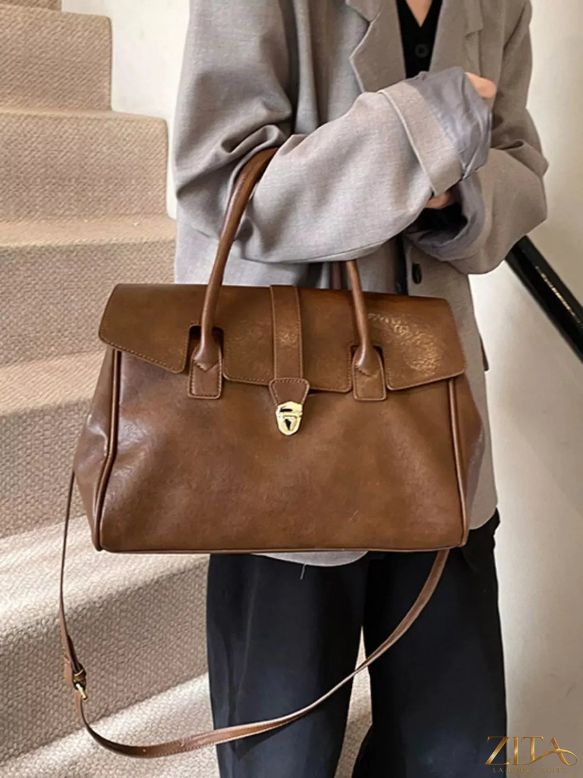 Buckle PU leather handbag by Trendsi featuring a sleek design, top handle, and stylish front buckle detail.