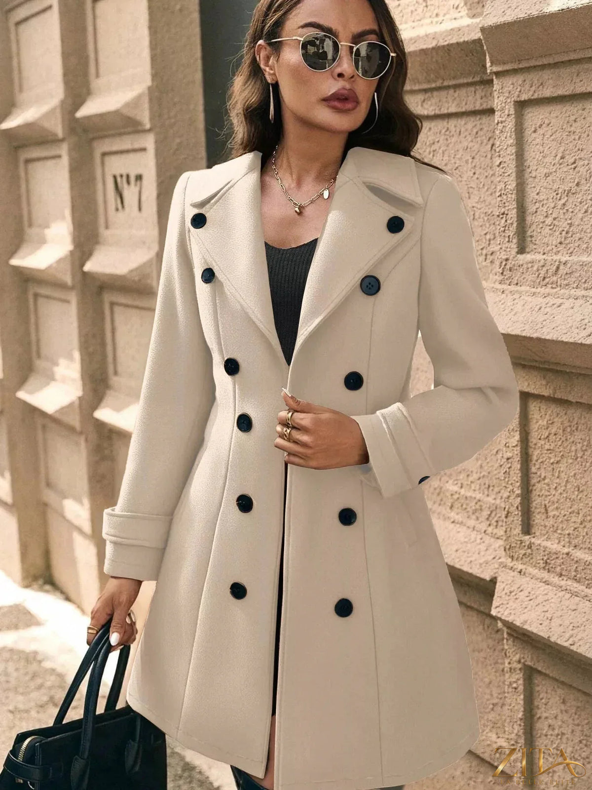 Zita La Belle Elite double-breasted wool blend overcoat hanging on a wooden hanger, showcasing its tailored design and classic style.