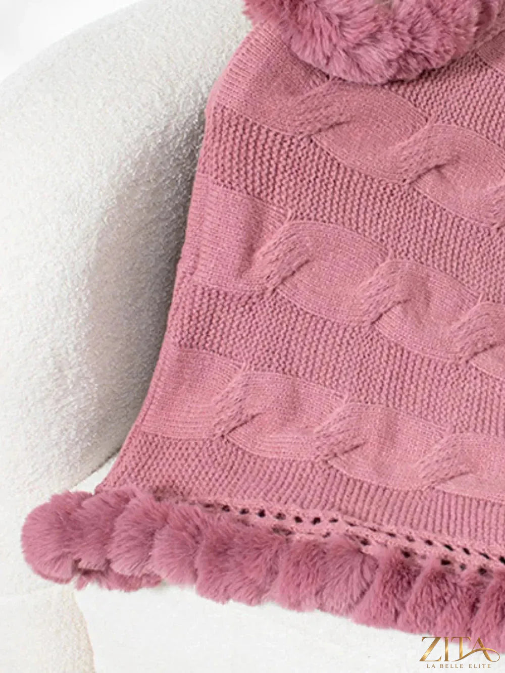 Fuzzy hem cable-knit poncho in cozy cream color, featuring a relaxed fit and textured knit pattern by Trendsi.