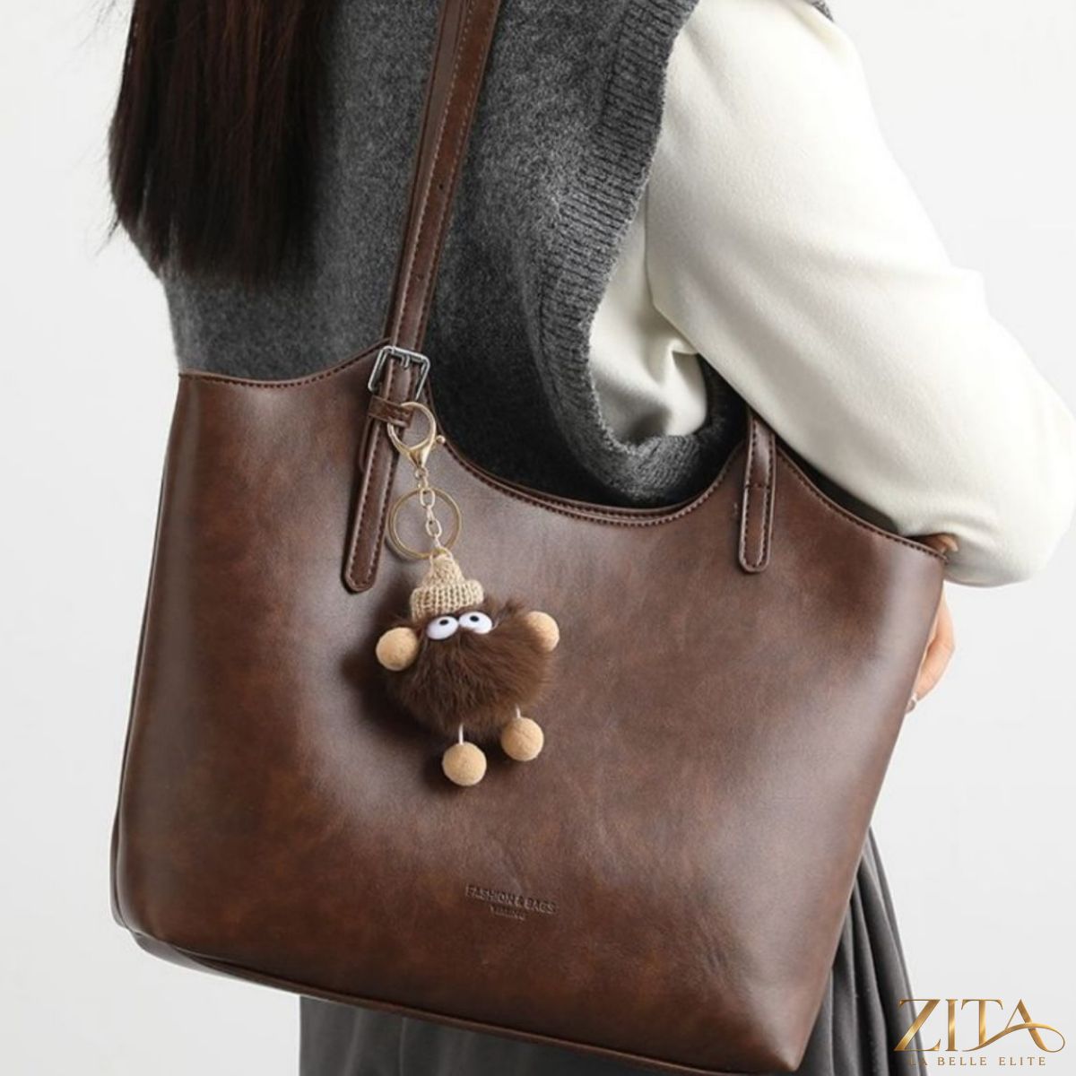 Leather tote bag with charm by Zita La Belle Elite, featuring a spacious interior and stylish design with decorative accessories.