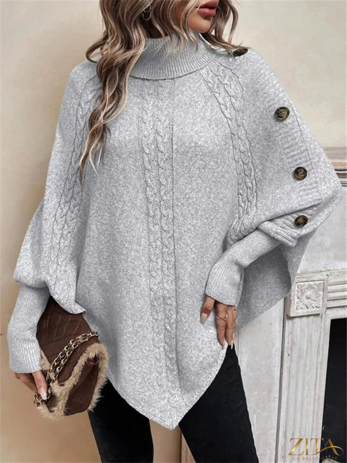 Cable knit turtleneck cape sweater by Trendsi, featuring a cozy, textured design with a high collar and flowing cape silhouette.