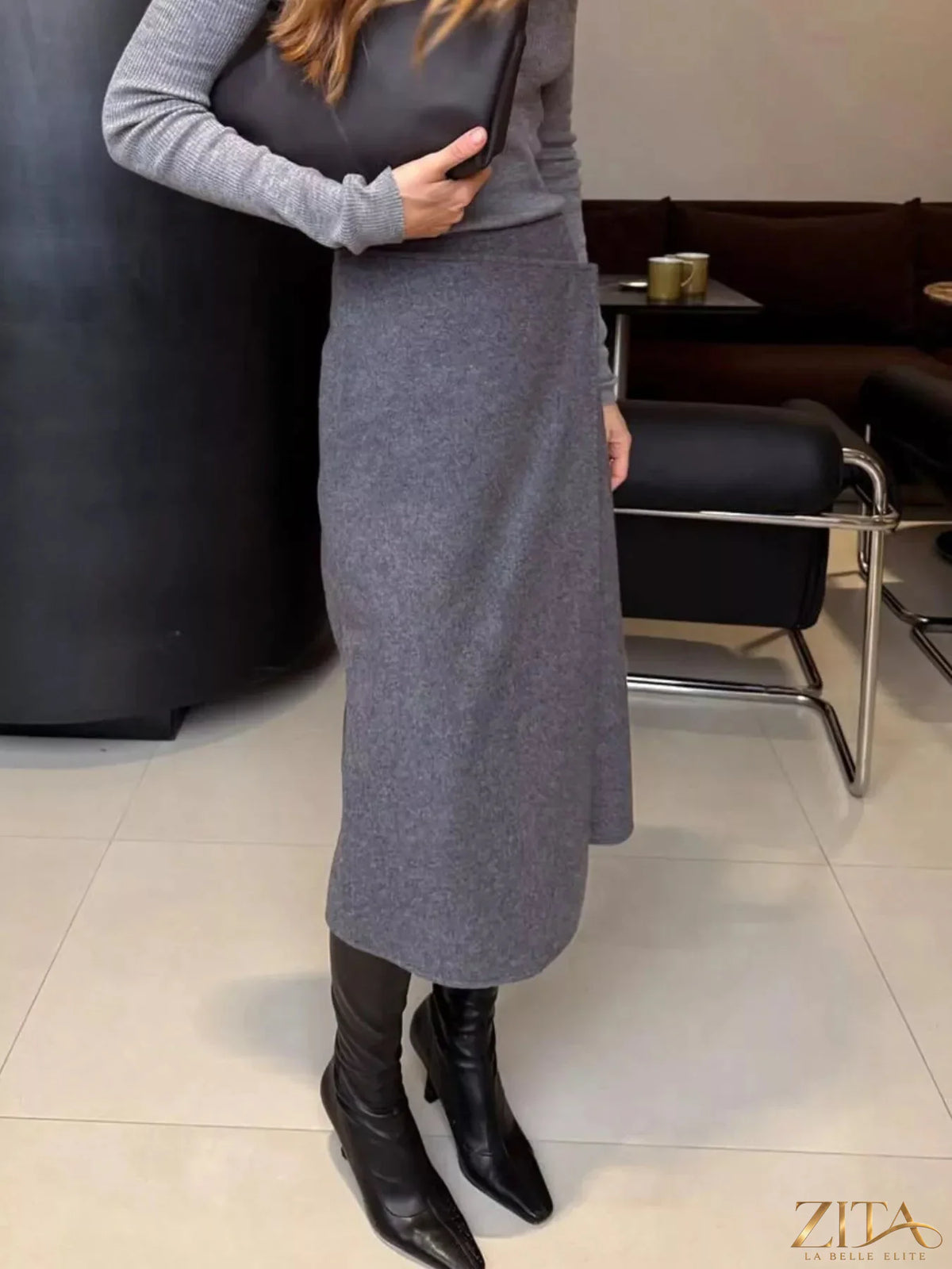 High-waisted wrap midi skirt in neutral fabric, featuring a stylish tie detail at the waist, perfect for chic, elegant looks.