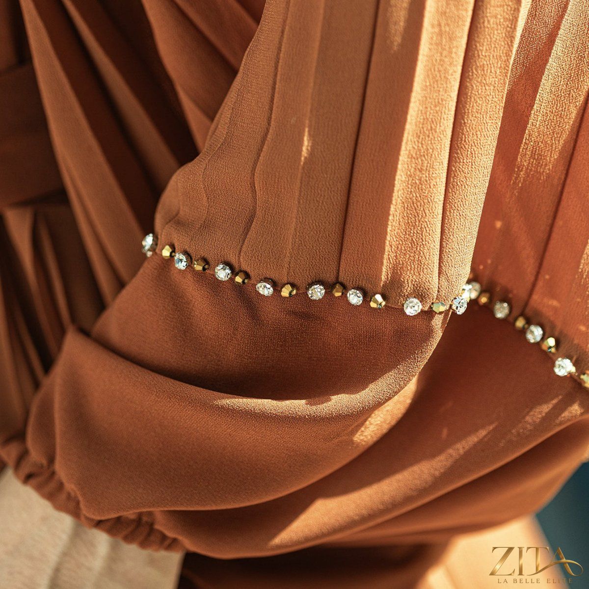 Zita La Belle Elite hand-beaded V-neck pleated maxi gown with bubble sleeves and crystal embellishments.